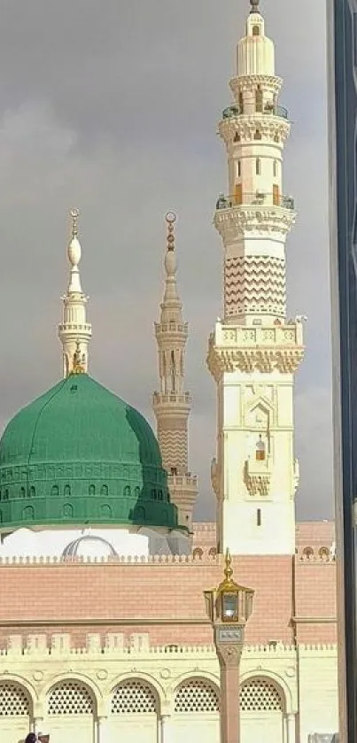 Green dome mosque with towering minarets and intricate architecture.