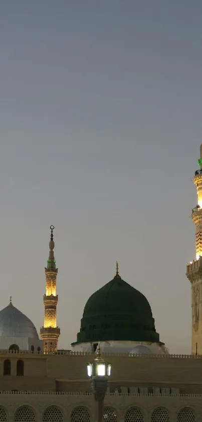 Mosque silhouette under evening sky with illuminated minarets for mobile wallpaper.