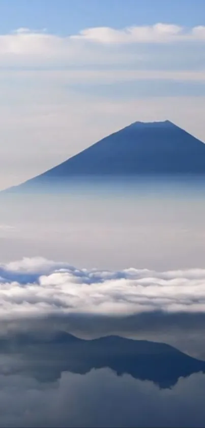 Majestic mountain peak above clouds on a blue sky.