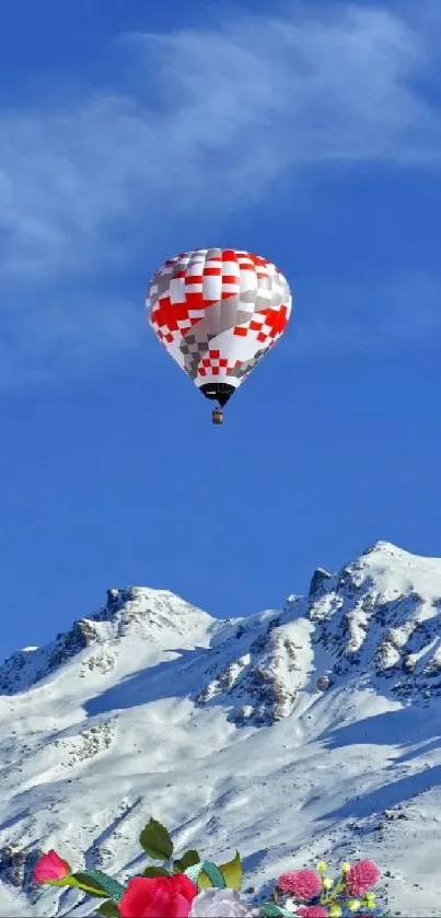 A hot air balloon over snowy mountains under a bright blue sky.