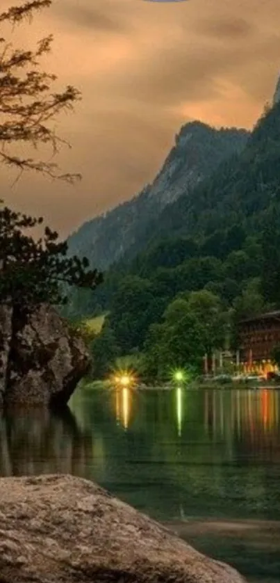 Serene mountain lake view at dusk with glowing lights and forest.