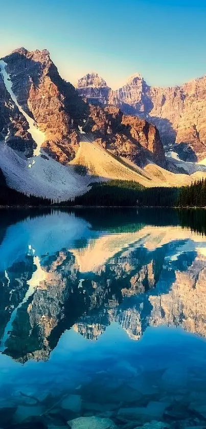 Stunning mountain range reflecting in crystal clear lake under blue sky.