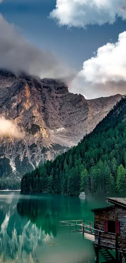 Serene mountain lake with a wooden cabin and misty peaks.