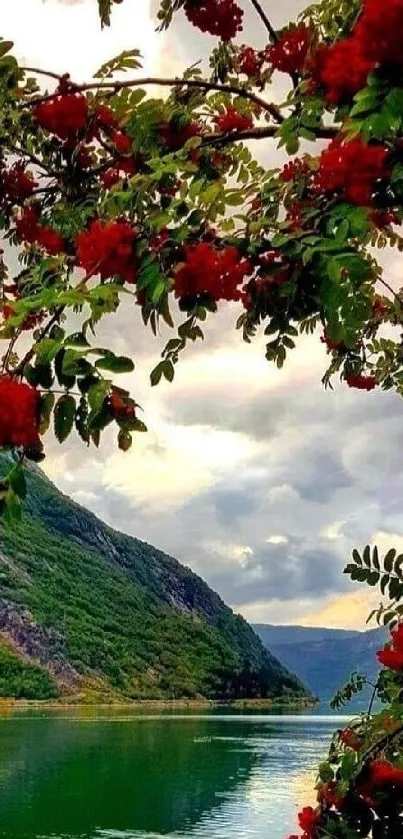 A serene mountain lake with red flowers and lush greenery.