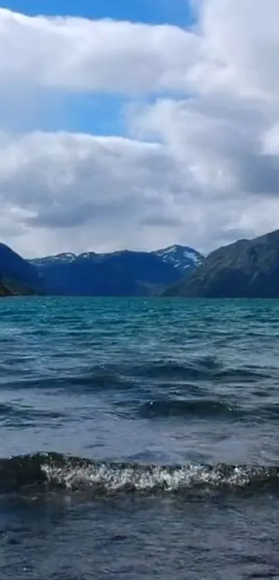 Serene mountain lake with blue water and cloudy sky background.