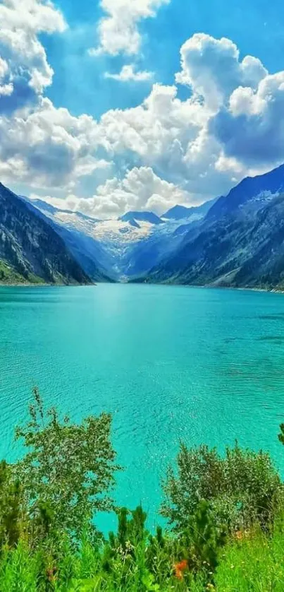 Serene blue-green lake surrounded by mountains and a vivid sky.