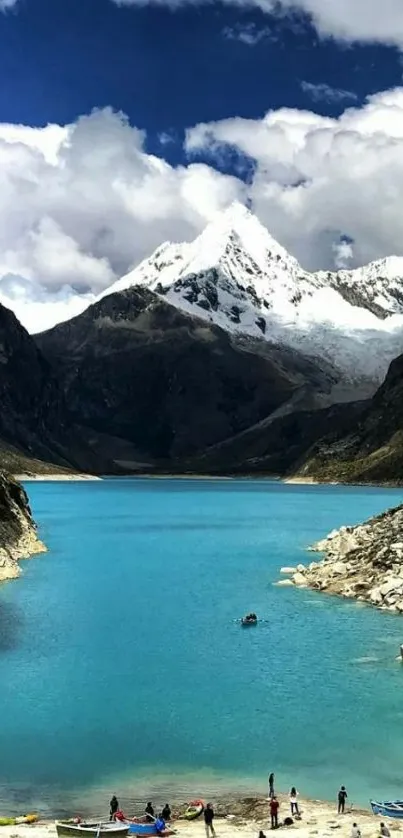 Turquoise mountain lake with snow-capped peaks and blue sky.