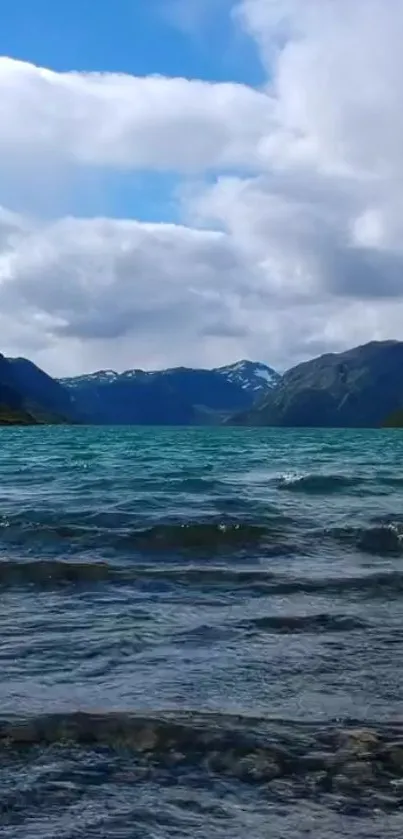 Serene mountain lake wallpaper with blue water and cloudy sky.