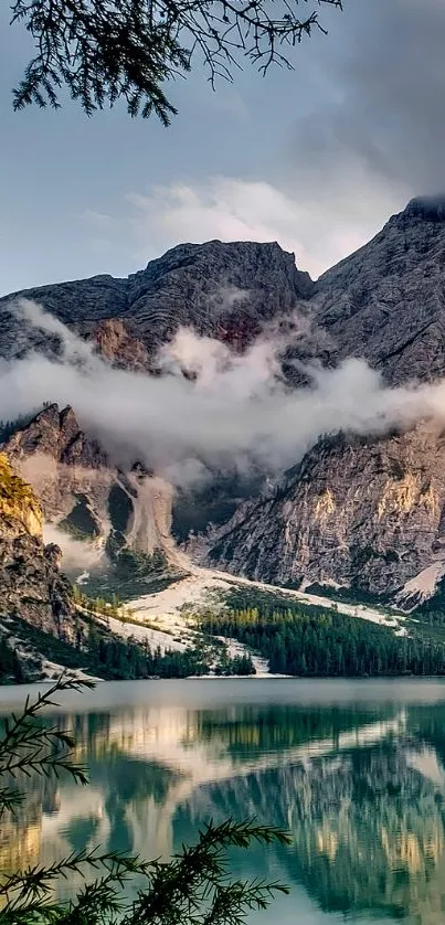 Serene mountain lake with misty peaks and lush greenery.