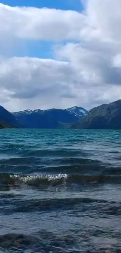 Serene mountain lake wallpaper with blue sky and waves.