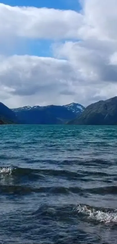 Serene mountain lake with blue water and cloudy sky background.