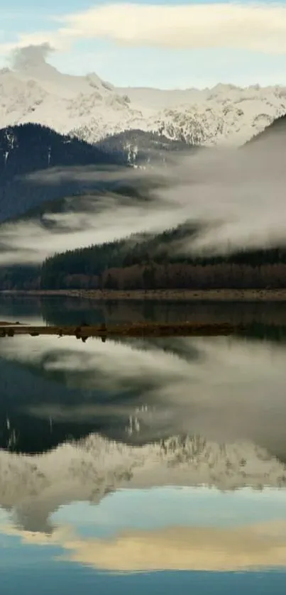 Mountain lake with misty reflection and snowy peaks.