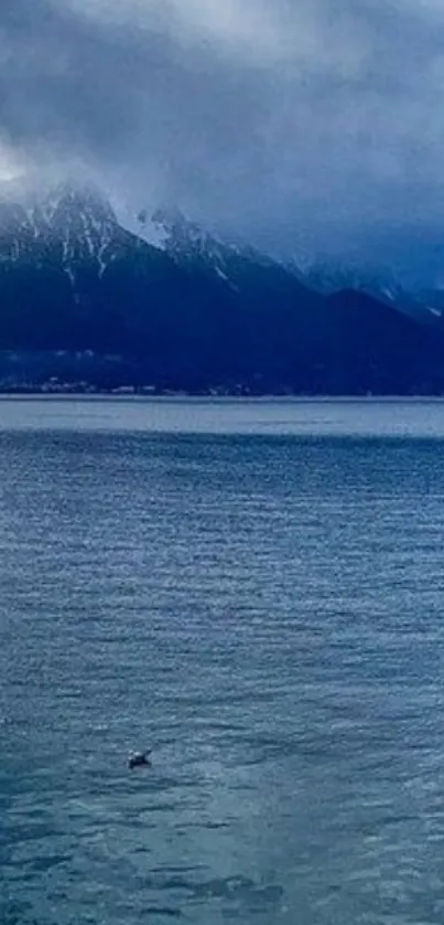 Serene view of a misty mountain lake with calm blue waters.