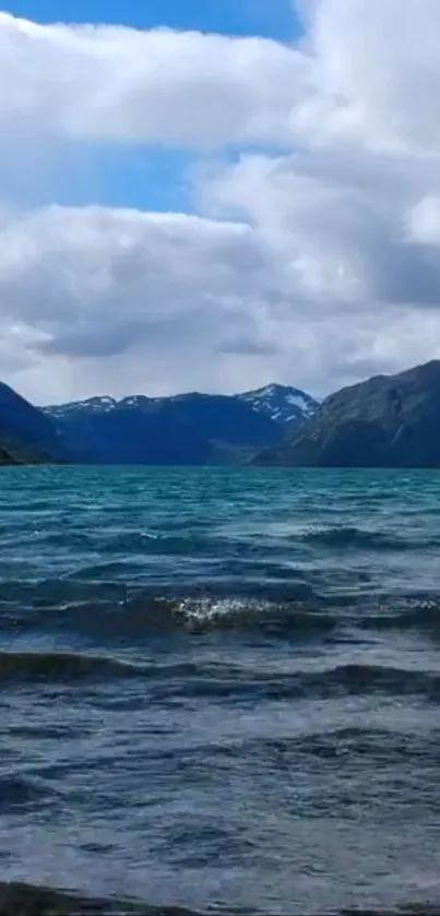 A serene mountain lake with cloudy sky.