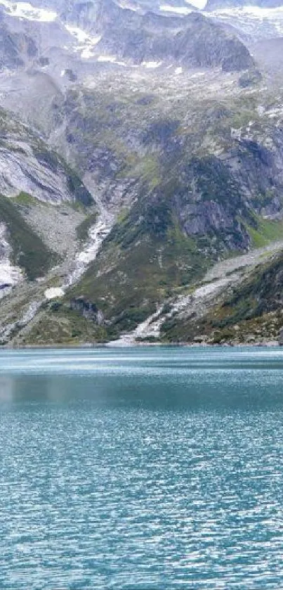 Serene mountain lake with teal blue water and towering peaks.