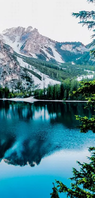 Serene mountain lake with reflection and snow-capped peaks.