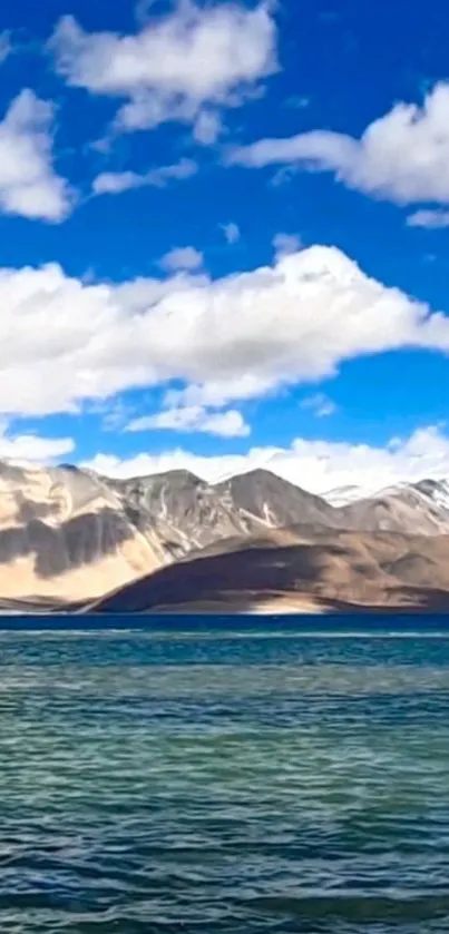 Tranquil mountain lake with blue skies and clouds.