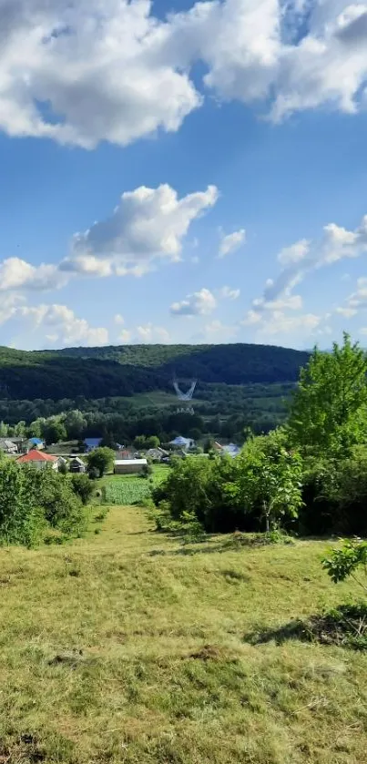 A serene view of green hills, blue sky, and distant mountains.