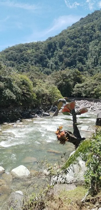 Serene river flowing through lush green mountains under clear blue sky.