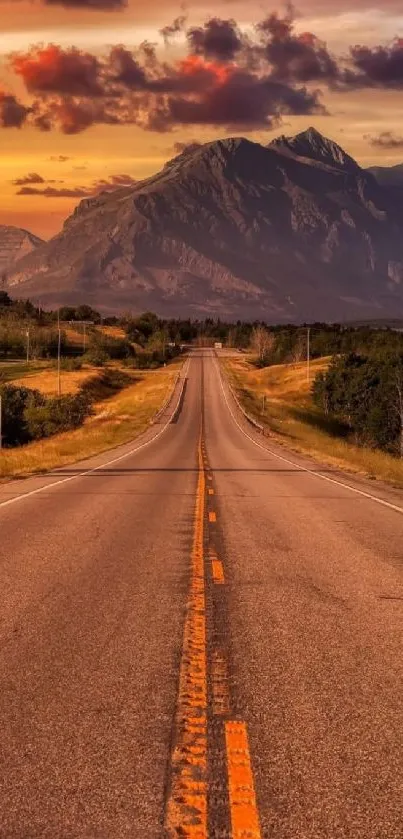 A serene mountain road under a vibrant sunset sky.