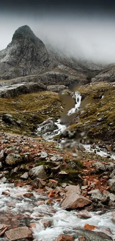 Mountain stream flowing through rocky landscape under misty skies.