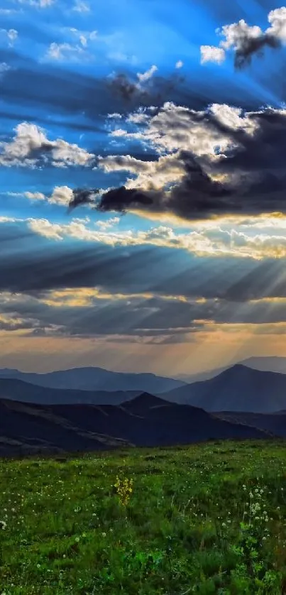 Mountain sunrise with sun rays and lush green hills.