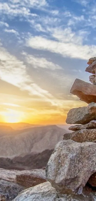 Rock pile with a sunset over mountains in the background.