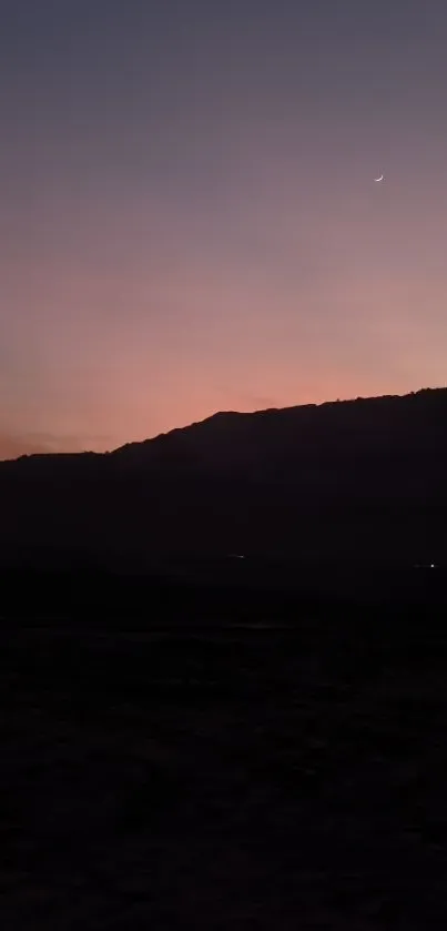 Serene purple sunset over silhouetted mountains.