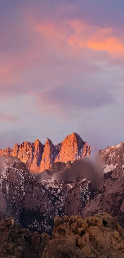 Serene sunset over mountains with a colorful sky and rocky peaks in view.