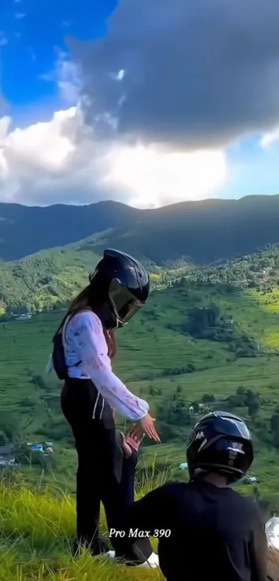 Breathtaking mountain view with two people in helmets overlooking lush landscape.