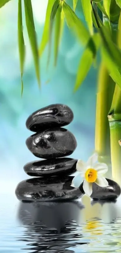 Balanced stones with bamboo and a white flower on rippling water.