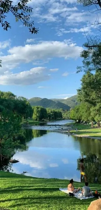 Serene riverside with trees and blue sky reflecting on water.