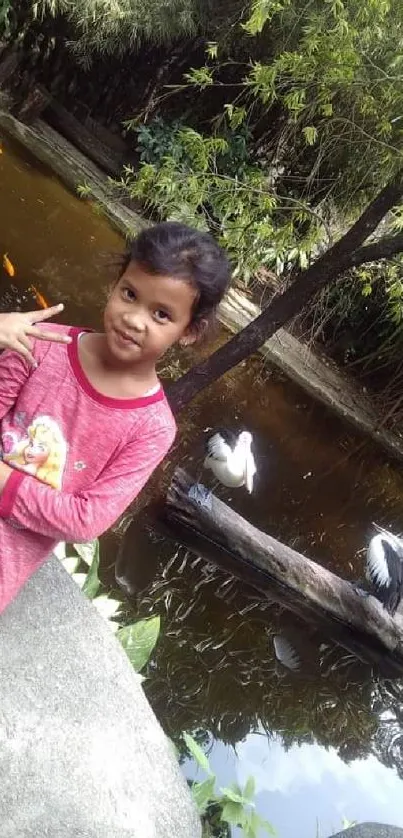 Child posing in a lush, green natural landscape with a calm water background.