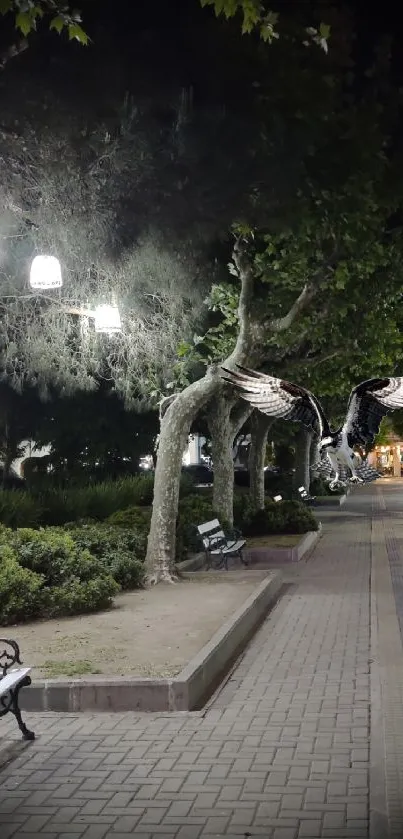 Tranquil night city pathway with illuminated benches and trees.