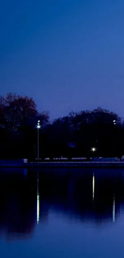 Tranquil lake at night with deep blue sky and reflections.