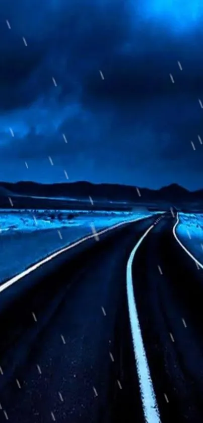 Dark road under a night sky with blue hues and gentle light.