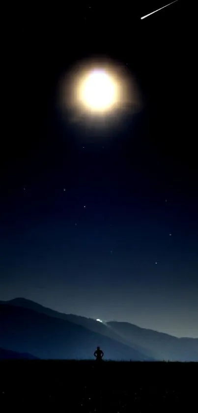 Bright moon in a night sky over silhouetted mountains.