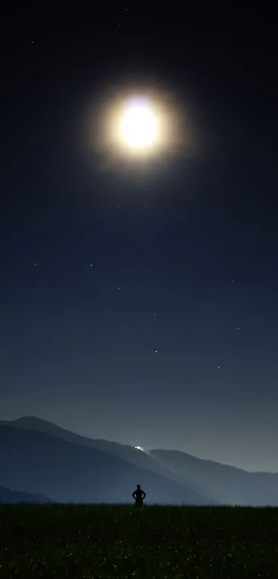 Silhouette under full moon in a serene night sky over mountains.