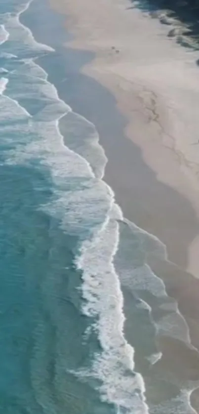 Turquoise ocean waves along a sandy beach coastline.