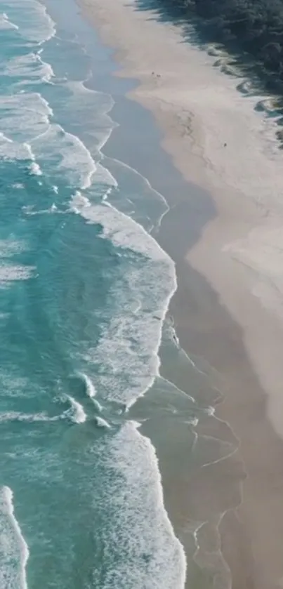 Aerial view of turquoise ocean waves meeting sandy beach.