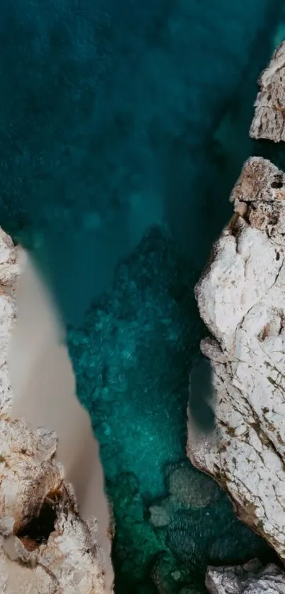 Aerial view of turquoise ocean with rocky cliffs.