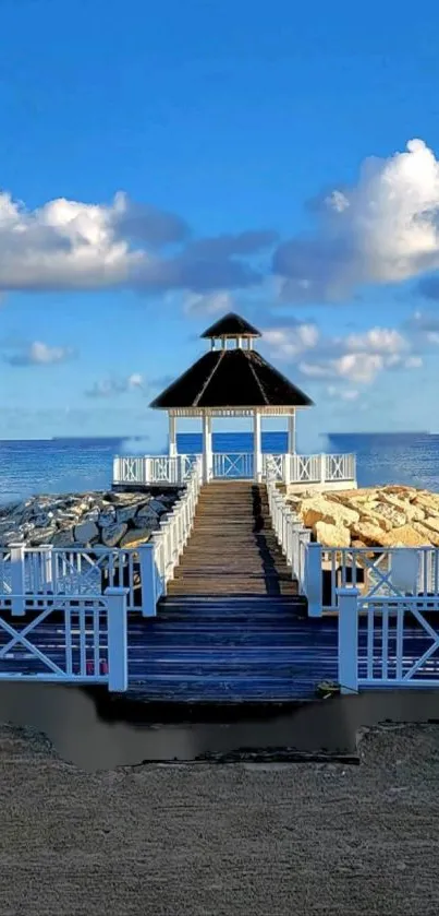 Serene gazebo on a pier with ocean view and blue sky.