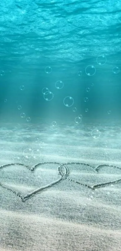 Underwater hearts in sand with ocean bubbles.