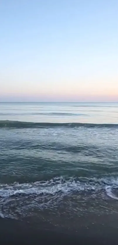 Tranquil ocean view with calm waves and a serene horizon at dusk.