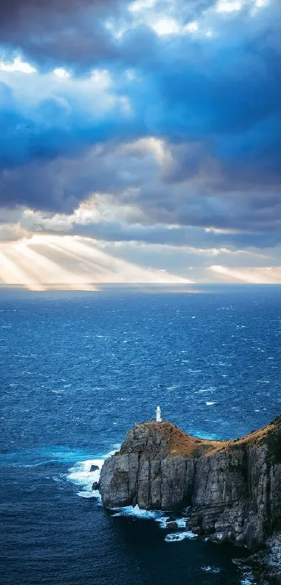 Serene wallpaper of ocean with lighthouse, clouds, and sunlight rays.