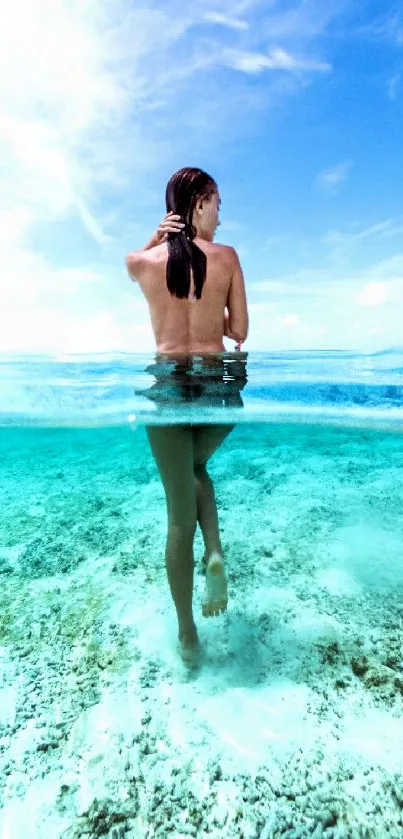 Woman standing in clear turquoise ocean under blue sky.