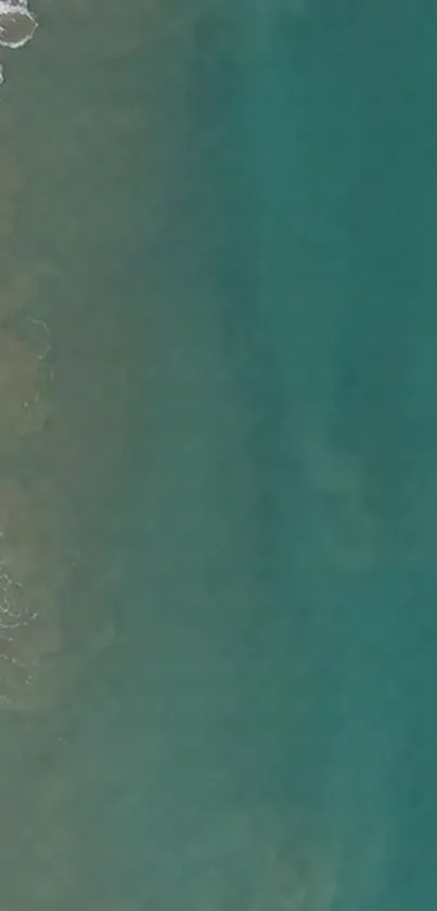 Aerial view of turquoise ocean waves meeting the sandy shoreline.