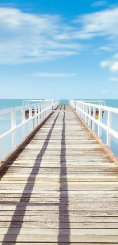 Serene view of a pier leading into the ocean under a clear blue sky.