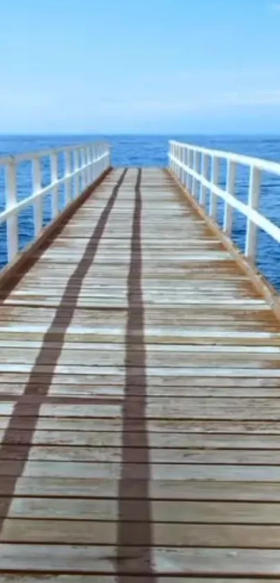 Wooden pier extending over calm ocean under blue skies.