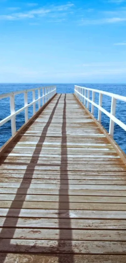 A peaceful wooden pier extending into the ocean under a clear blue sky.